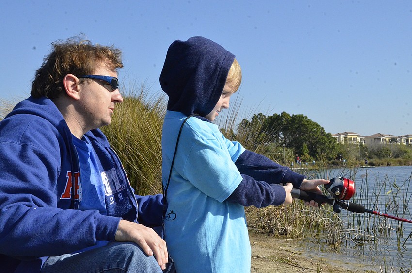 Stephen Murray of Mill Creek helps his done Benjamin for his first time fishing.
