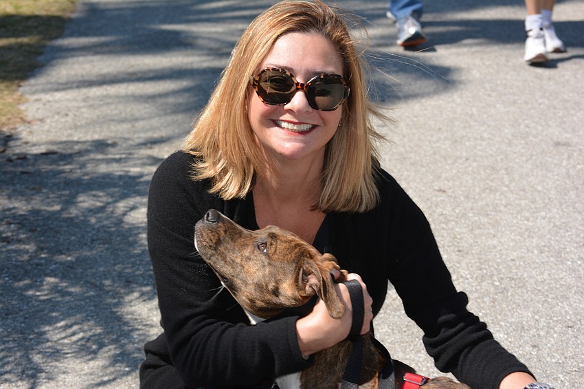 Event Co-Chair Jessica Ortiz, plays with her dog JJ. an 11-month-old she adopted from Nate's Honor Animal Rescue.