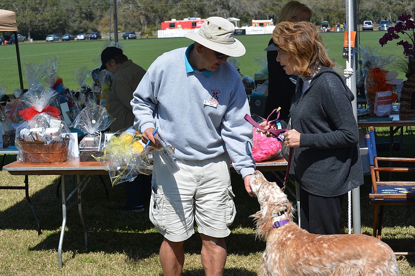 Peter Lipscomb, a Nate's Honor Animal Rescue volunteer, pets Natalie Salmore's champion English Setter, Sunshine.