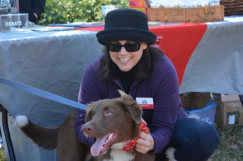 Lori Ruth, associate publisher of the East County Observer, takes time from handing out dog biscuits in her event sponsor's role, to visit with one of the stars of the day.