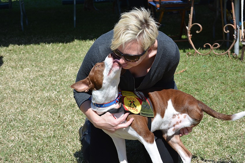 Bradenton's LaVonne Bower gets a kiss from Oz, who lost one of his back legs and was ready to be put down when he was saved by Nate's Honor Animal Rescue. Bower adopted Oz.