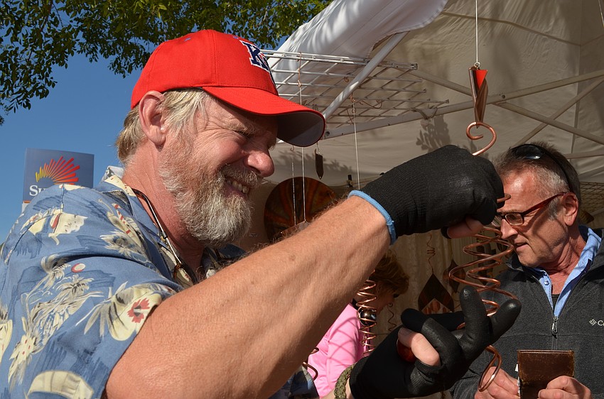 Artist Robert Boyce adds marbles to customize a metal coil for a customer.