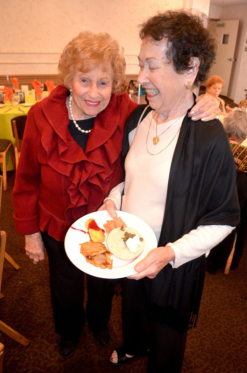 Helen Sherman and Bernice Lasberg share laughs while finding their seats.