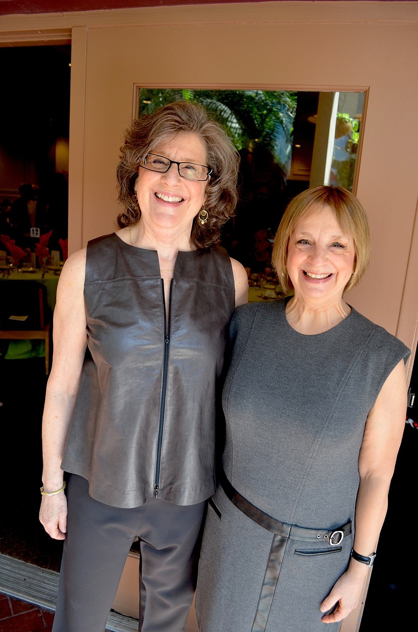 Sisters Judy and Peggy Moss wear matching smiles and gray outfits.