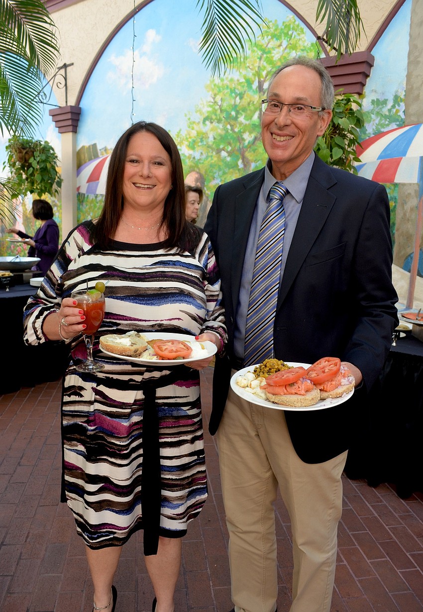 Dina and Mark Phillips fill their plates and their glasses with morning cocktails and breakfast.