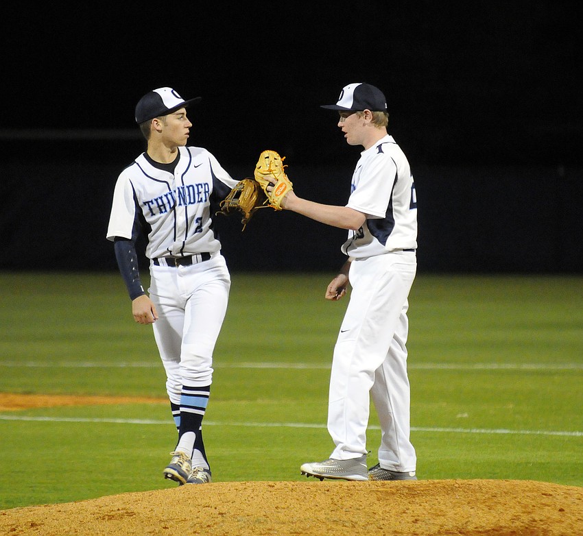 ODA third baseman Berrian Holland gives pitcher Alexander Denler some words of encouragement before the start of the inning.