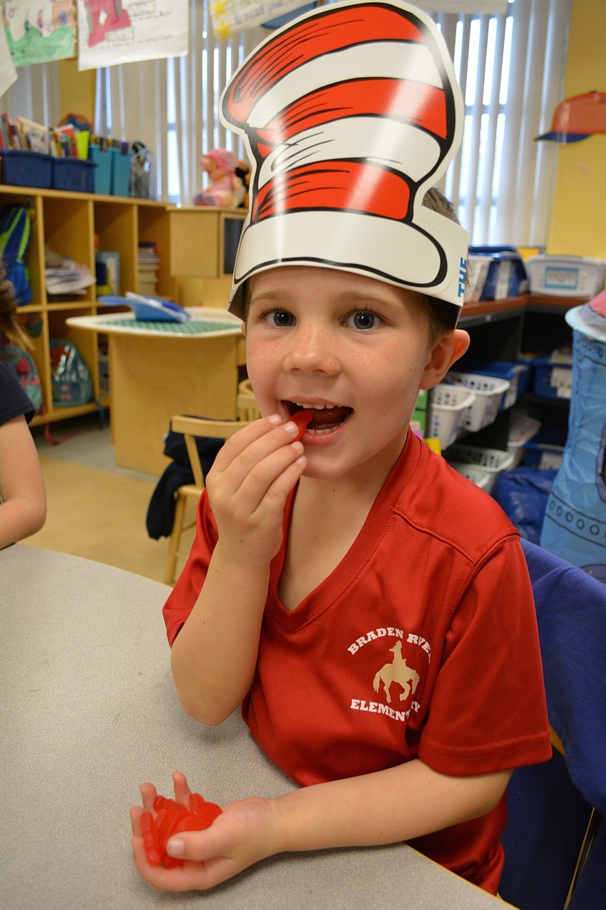 Braden River Elementary kindergartener Brayden Ridenour tastes a red fish in honor of Dr. Seuss.