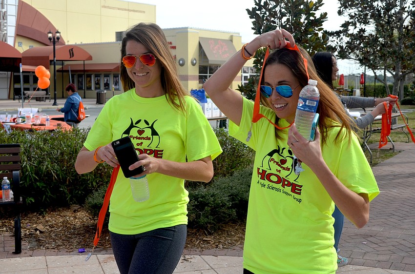 Sarah Scarlett and Kristina Barrow, of Bradenton, receive their medals after finishing the 3k.