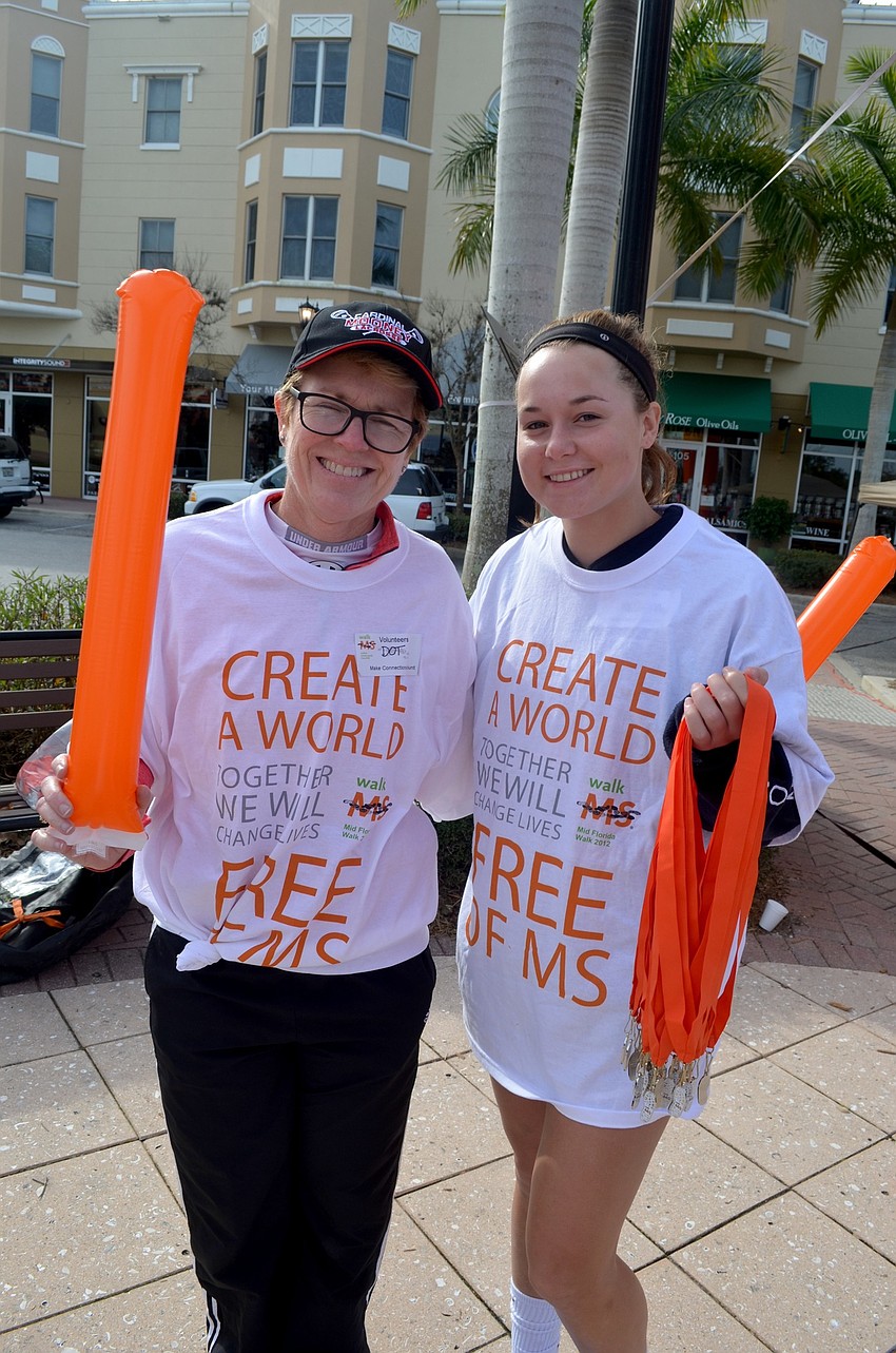 Event volunteers Dot Sorensen and Maddie Allen, of Lakewood Ranch, greet participants at the finish line.