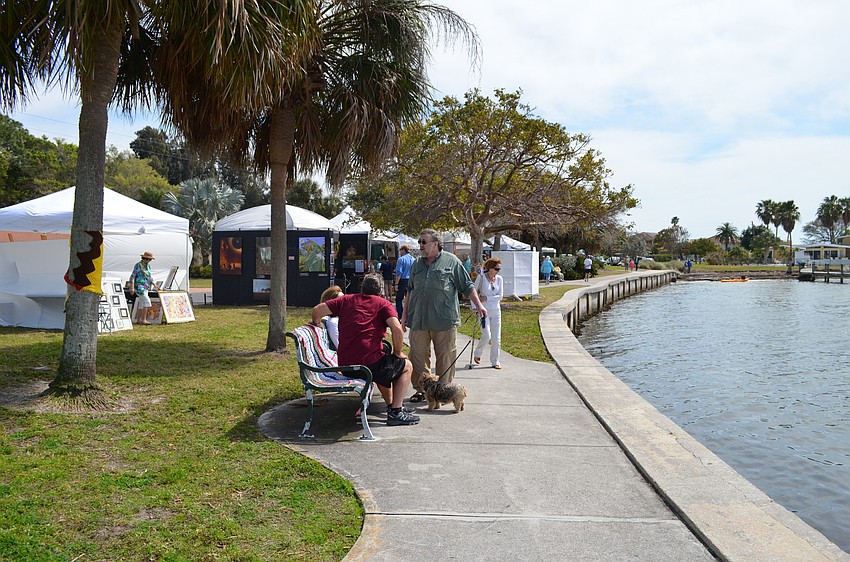 Vendors and residents stroll the waterfront Sapphire Shores park during the 4th annual Sun Circle Art Festival.