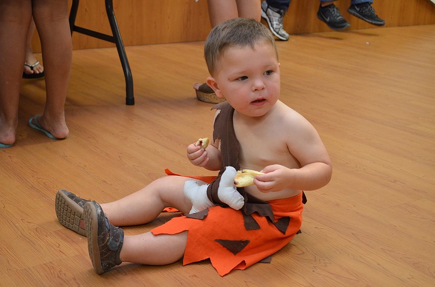 Abner Beck, 1, dressed as Fred Flintstone enjoys a raspberry hamantaschen cookie.
