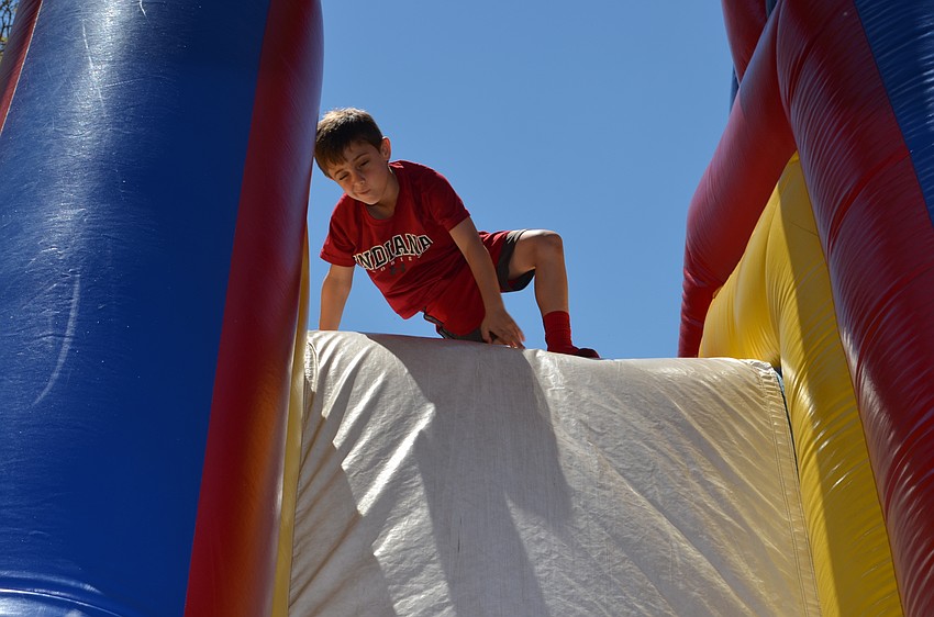 Drew Smith climbs over the inflatable obstacle course.