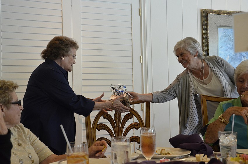 Peggy Caywood of The Moorings gets her raffle prize from Sara Kasten.