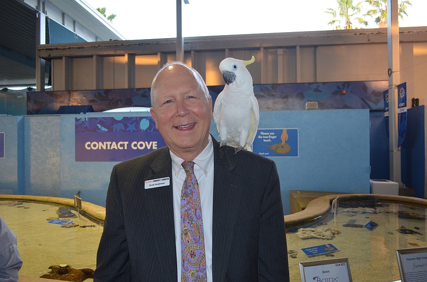 Master of Ceremonies Scott Anderson, of the Gulf Coast Community Foundation, with Kelly, a greater sulphur-crested cockatoo
