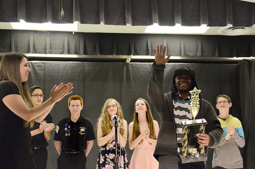 Sarah O'Kelly, chorus teacher and talent show organizer, awards EJ Davis the winner's trophy.