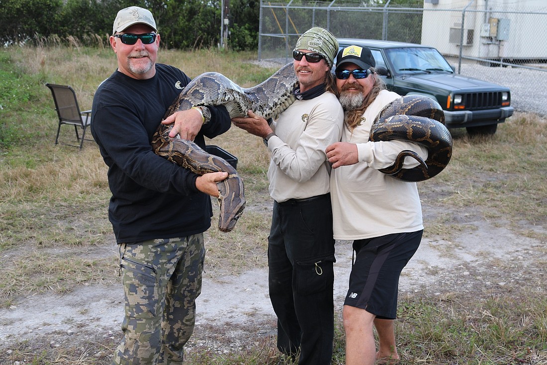 Bill Booth, Duane Clark and Dusty Crum with the 15-foot python. Photo courtesy Bill Booth.