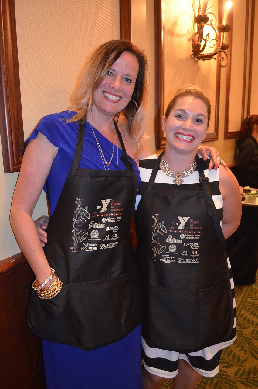 Stacey McKee and Jamie Rasnak find their aprons for their cooking debut.