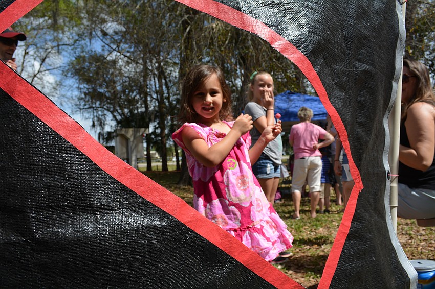 Ava DiPasquale, 4, throws a bean bag through a shaped hole.