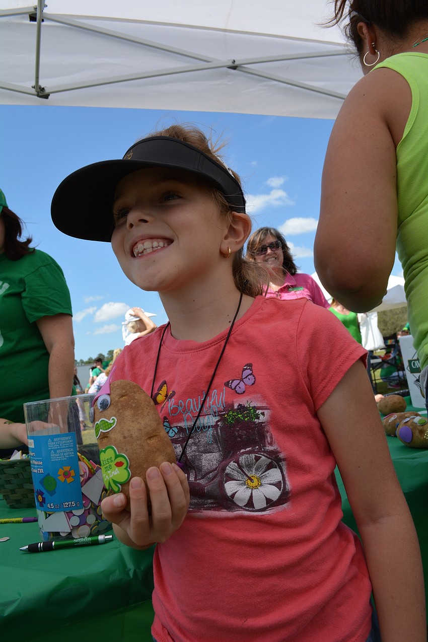 Afton Kurek, 8, holds a potato face she made for her grandma.