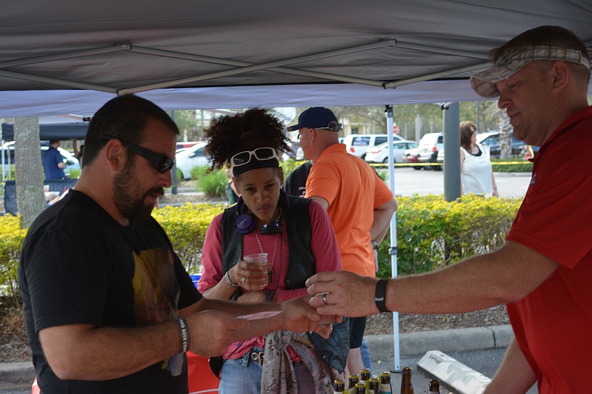 Tony Conte and Flor Williams of Sarasota are served craft beer by Justin Poppa, the territory sales manager for Gold Coast Eagle Distributing, an event sponsor.