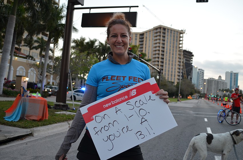 Erin Spiccia stands with the team from Fleet Feet Sports to cheer on runners.