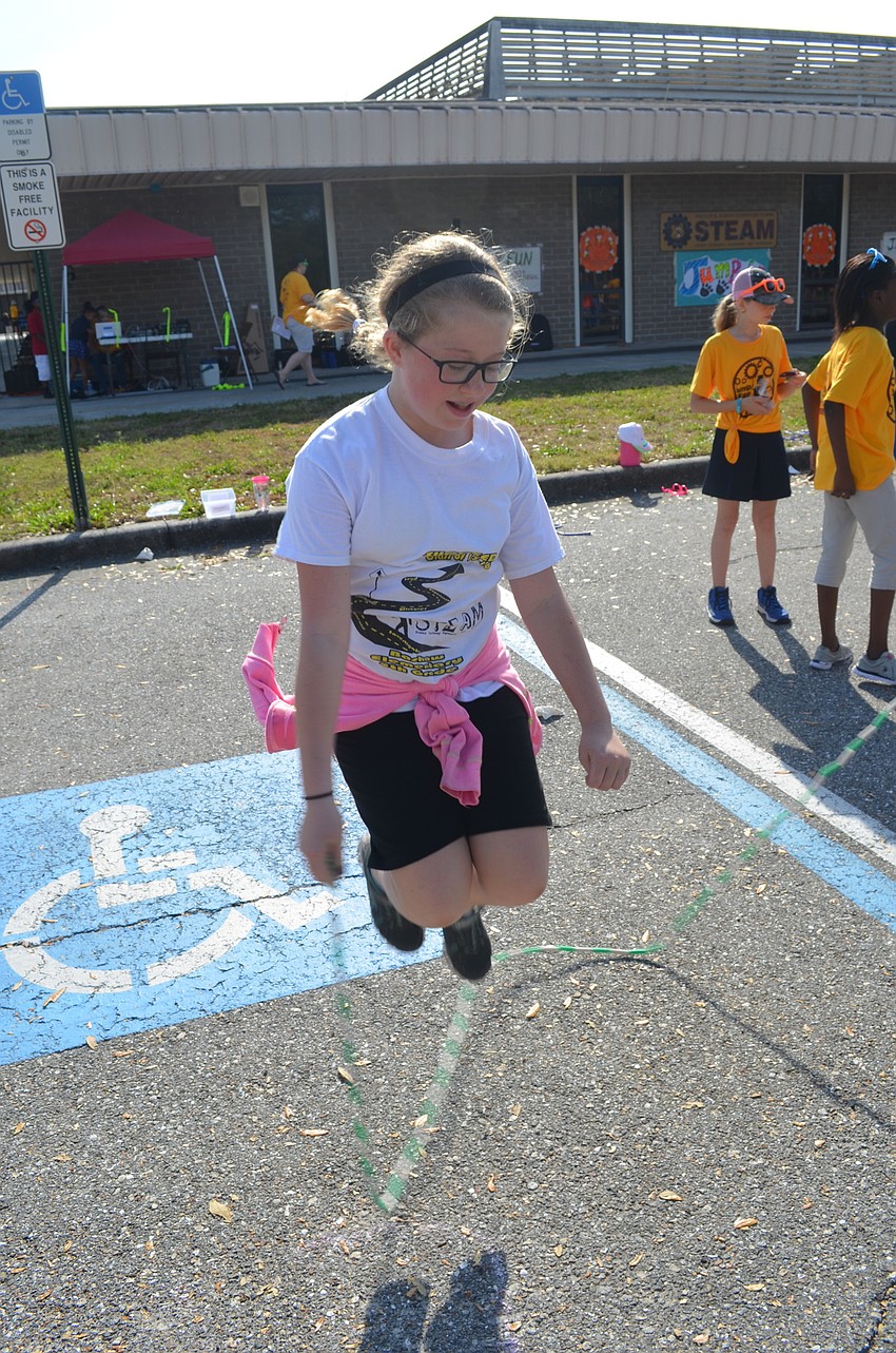 Mea Adkins holds the jump rope while she jumps as high as she can.