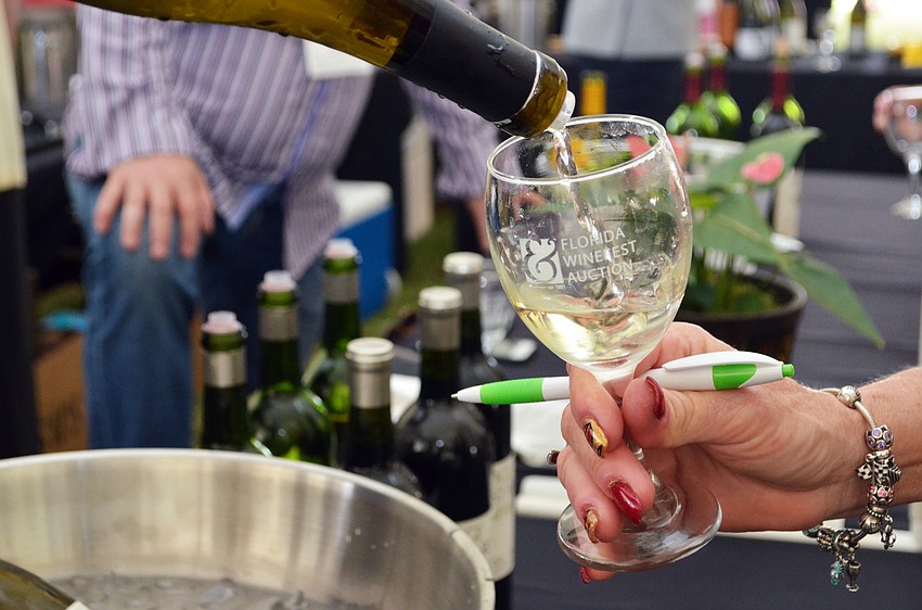 Guests enjoy a wine tasting at the Florida Winefest and Auction Bayfront Showcase Lunch.