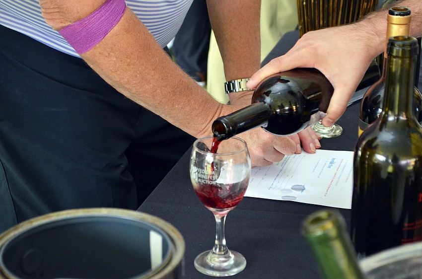 Guests enjoy a wine tasting at the Florida Winefest and Auction Bayfront Showcase Lunch.