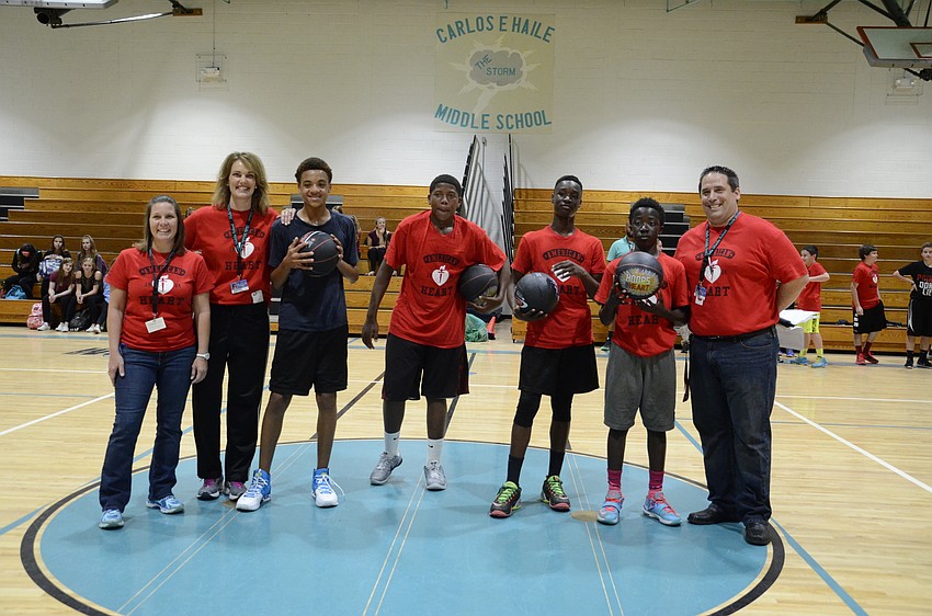 Assistant Principal Kate Collins, Principal Sharon Scarbrough and Assistant Principal Bob Sloman congratulate the top players, Omarius Miller, Shamar Beatty, Cedric Bullard and Caleb Azor.