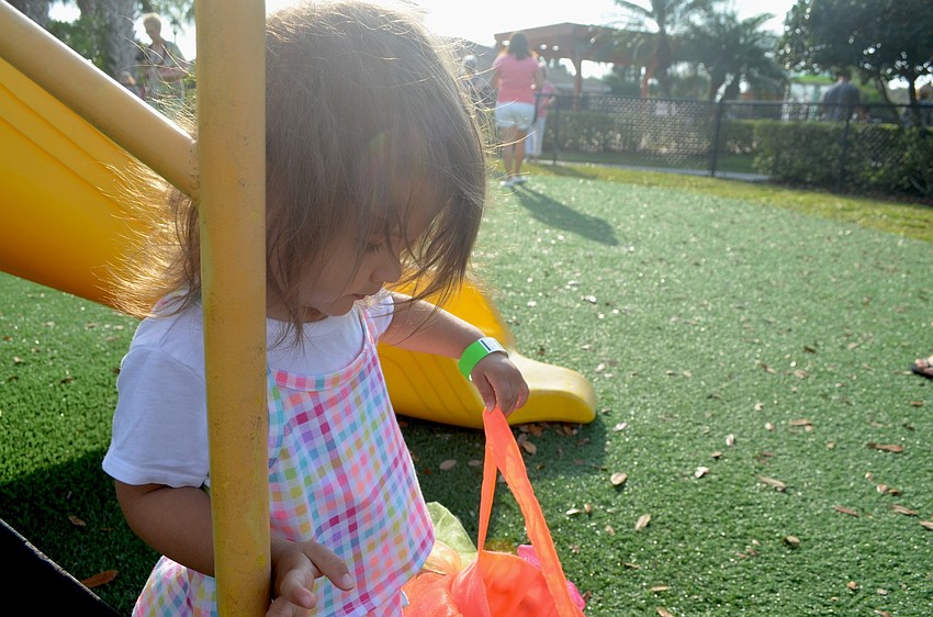 Two-year-old Lily Zientara checks out her loot — a basket full of plastic eggs.