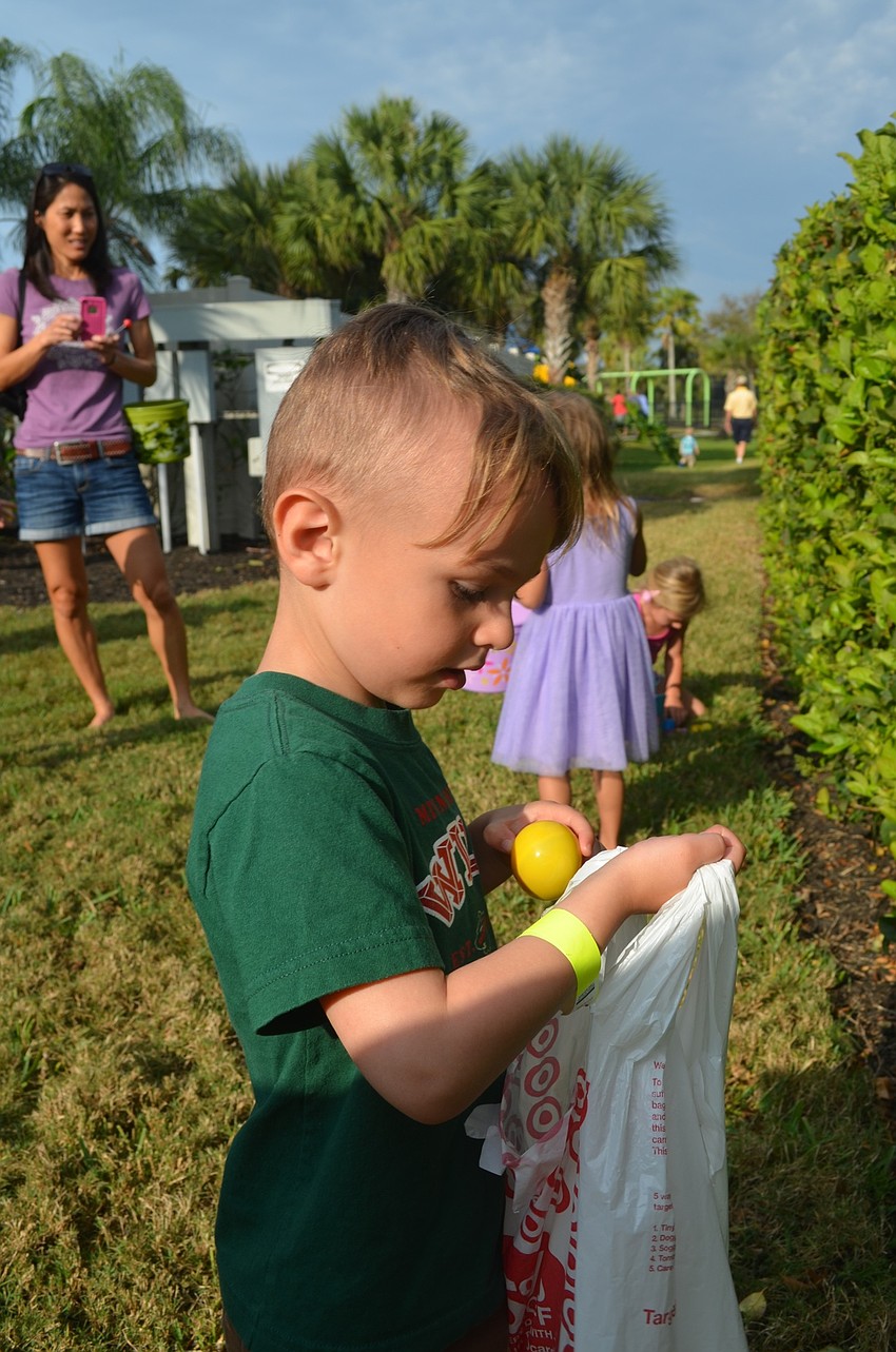 Three-year-old Cole Beaudry finds multiple eggs in the bushes.