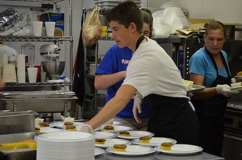 Calvin Holton helps plate meals with cornbread.