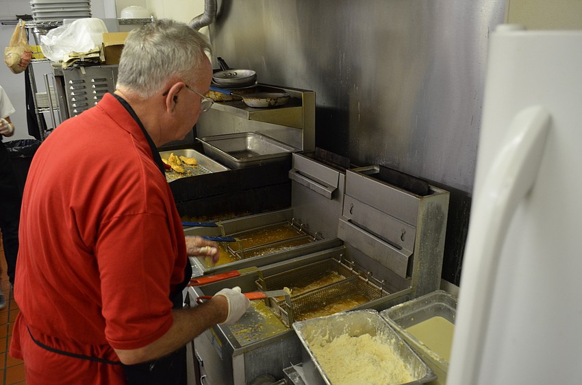 Dick Walker of Walker Catering checks on baskets of fried fish.