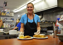 Jane Holcomb serves up to of the meals Friday evening at St. Boniface Episcopal Church on Siesta Key.
