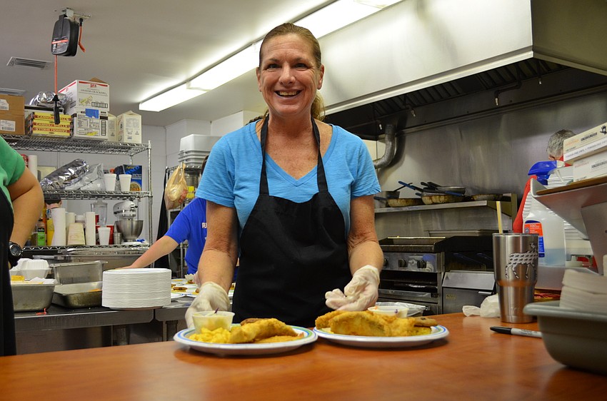 Jane Holcomb serves up to of the meals Friday evening at St. Boniface Episcopal Church on Siesta Key.
