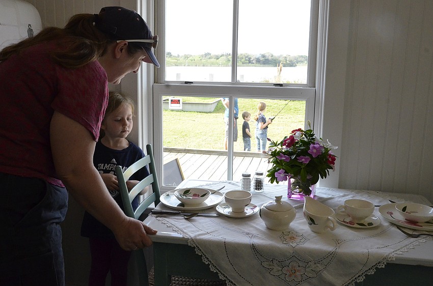 Theresa and Rebecca Coblentz of East Bradenton examine an antique table setting.