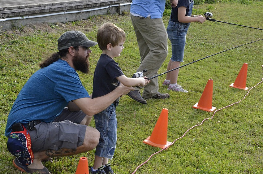 Joshua Coblentz of East Bradenton helps his son Joshua practice casting.
