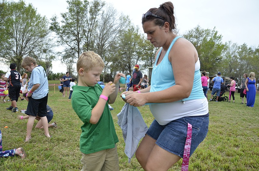 Eli Carvin gets a little help holding his egg stash from his mom, Sami Carvin of East County.