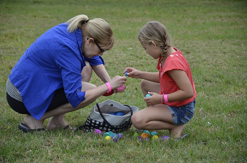 Lexi Joyal of Stoneybrook, right, gets help from her aunt, Shelley Jack, extracting candy from the eggs.