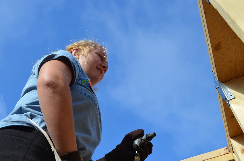 Hannah Hines reaches uses palm nails in the interior of the house.