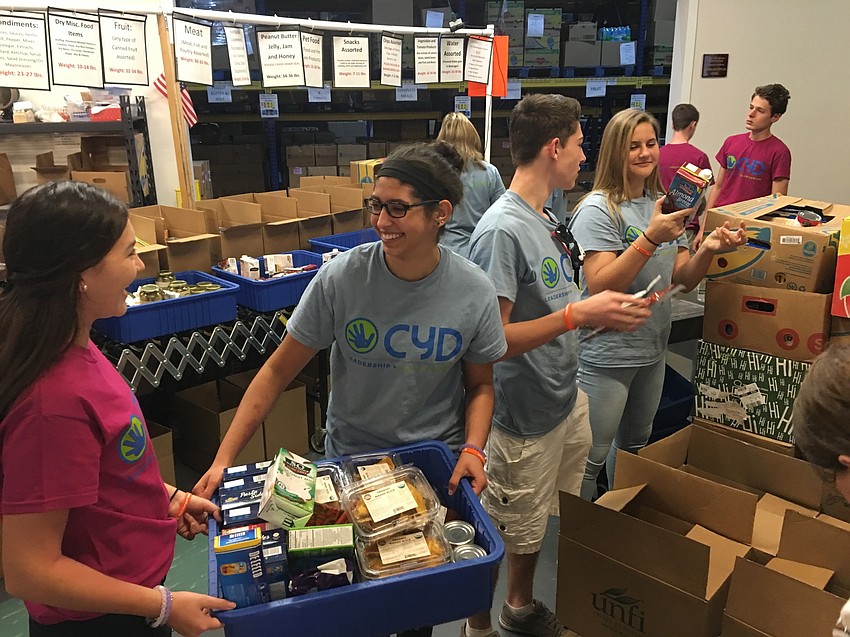 Courtesy photo. Community Youth Development volunteers sort and pack food at All Faiths Food Bank as part of the Alternative Spring Break.