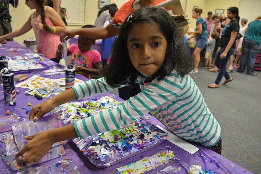 Vijaya Kethireddy, 7, a student at Willis Elementary, makes a tie-dye bookmark.