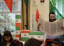 Rabbi Mendy Bukiet reads from the Megillah, or Scroll of Ester, which recounts the salvation of the Jewish people from a Persian vizier.