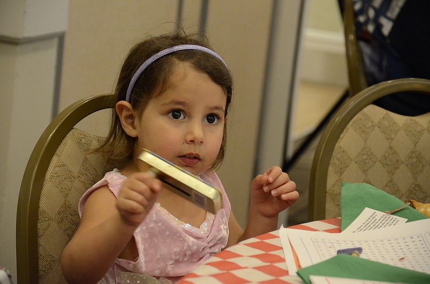 Eden Tibi shakes a rattle, a tradition during the reading of the Megillah to drown out the name of Haman, an evil Persian vizier.