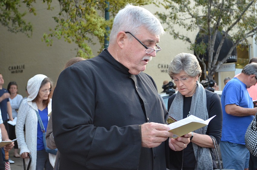 The Rev. Richard Marsden follows along in song during the Church of the Redeemer Stations of the Cross.