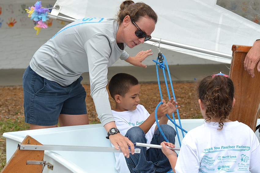 Alana O'Reilly of Sarasota Youth Sailing explains the parts of a sailboat to Noah Ulloa.
