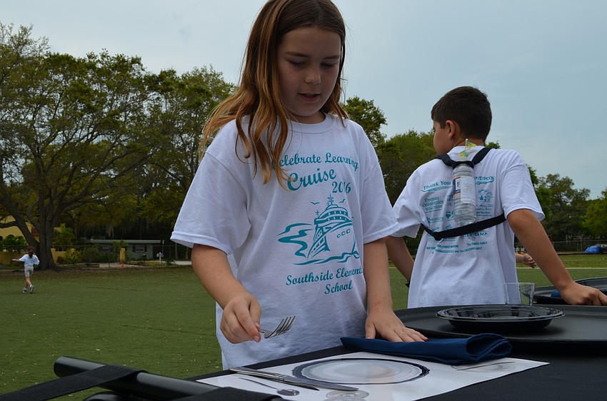 Kaia Nelson tries to match the utensils and plates to the mat for the No Waiting hospitality relay race.