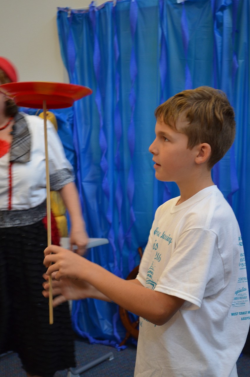 Luca Patarnini learns to balance a plate at the Lido Deck station.