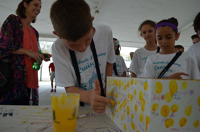Rudy Carter adds his fingerprint to the beehive that will be installed at the Ritz Carlton golf course.