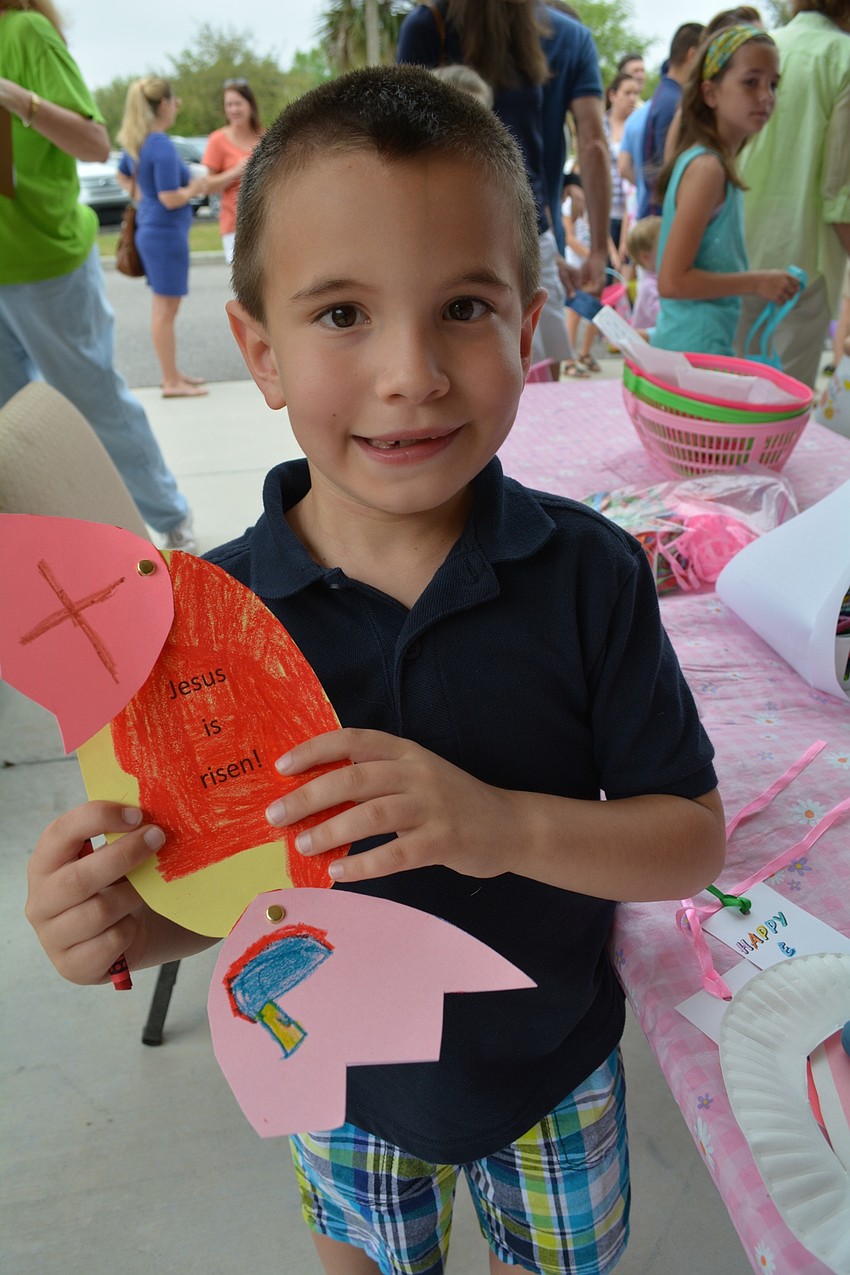 Jacob Gomez, 6, makes a craft while helping his mom, Heidi Thompson, man an activity table.